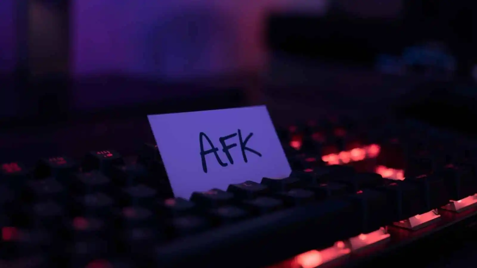 A note with the letters AFK rests on a computer keyboard.