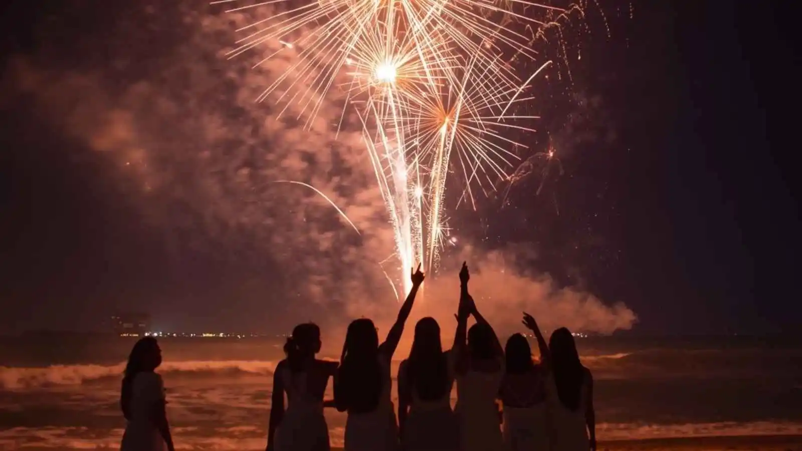 Fireworks lighting up the night sky during a lively New Year celebration on the beach